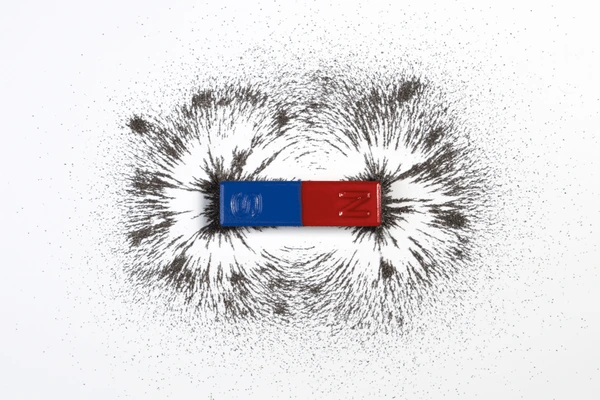 Stabmagnet mit magnetischen Feldlinien und Eisenspänen in einem Klassenzimmerexperiment