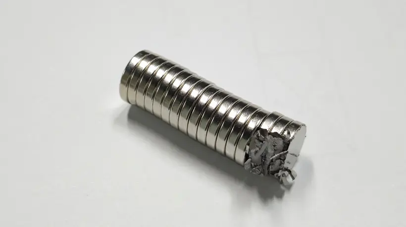 Close-up view of a neodymium magnet showing its brittle, metallic structure