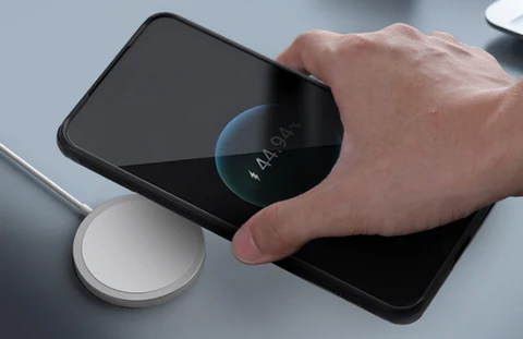 磁気ケースを使用したワイヤレス充電パッド上のスマートフォン。誘導充電との互換性を示しています。.