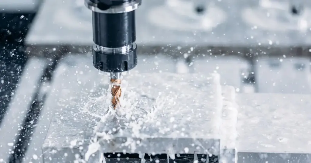 Technician drilling a magnet using a diamond-coated drill bit with continuous coolant.